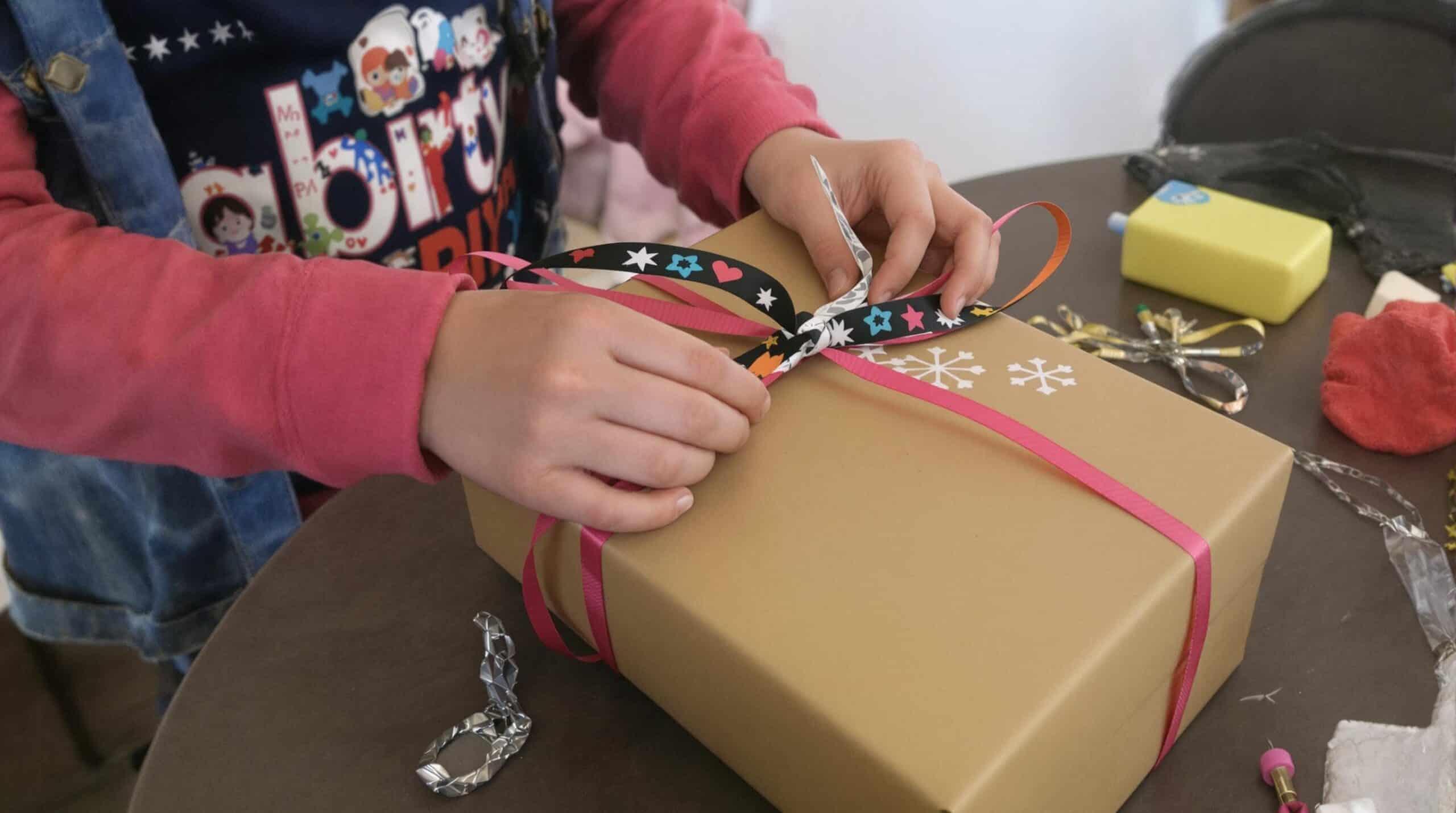 Un niño envuelve un regalo casero