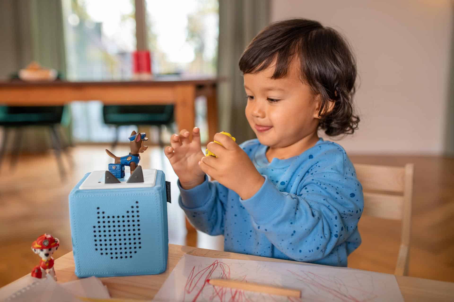 Un niño escucha a un Tonie en el comedor.