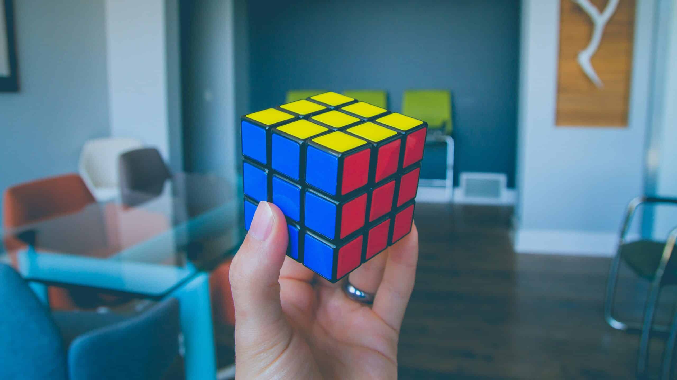 Una mano sostiene un cubo de Rubik resuelto
