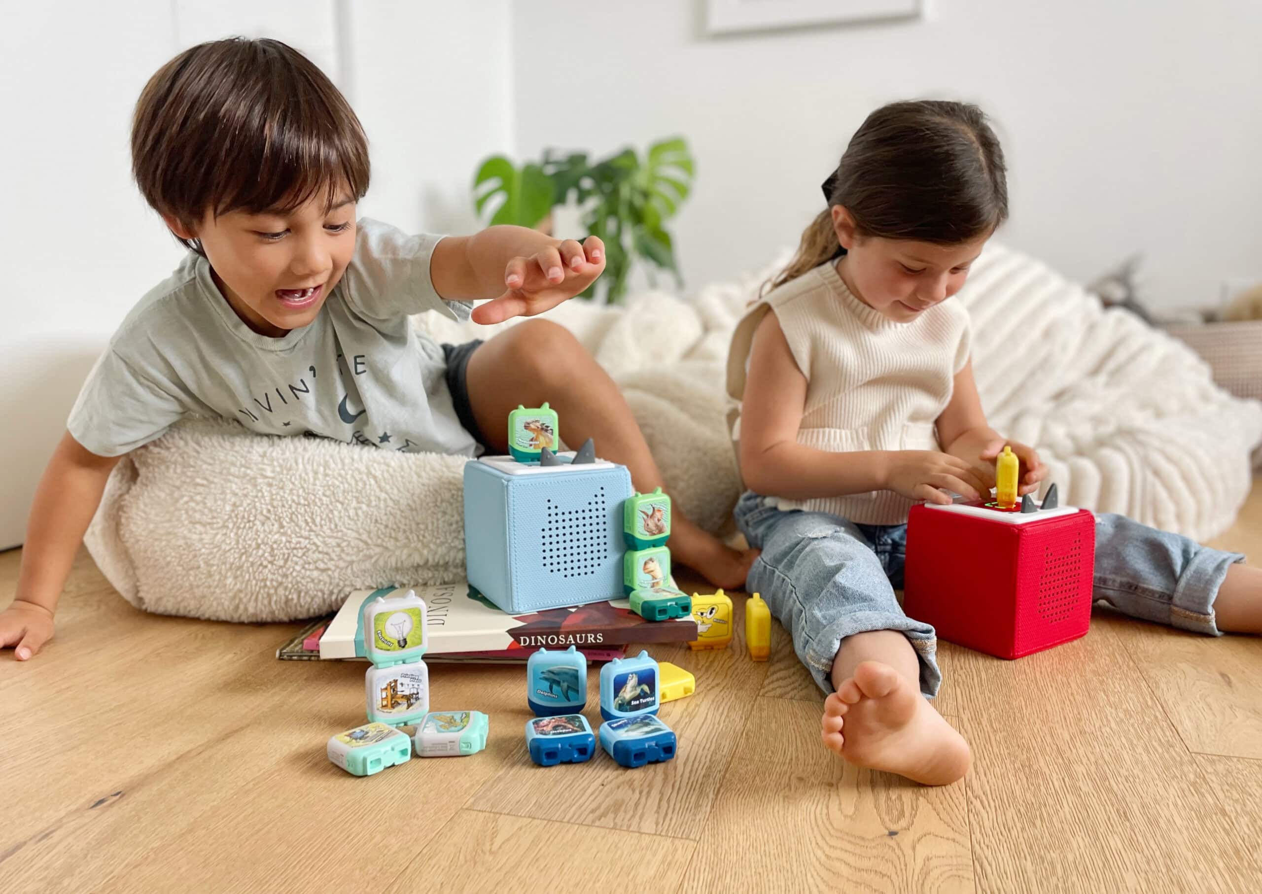 Dos niños están sentados en una guardería escuchando Tonies en sus Tonieboxes.
