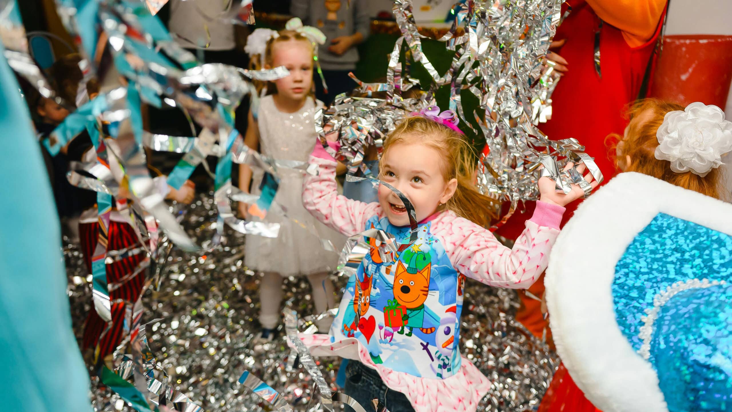 Dos chicas saltan en una habitación llena de espumillón